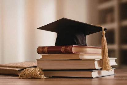 Referencial. El birrete universitario sobre libros simboliza la culminación académica y el registro oficial de títulos en Ecuador.