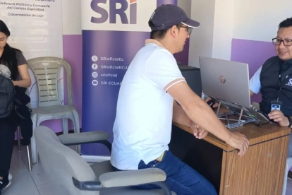 Una persona pregunta a técnicos del SRI sobre beneficios tributarios.