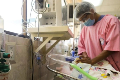 Un integrante del personal hospitalario da de comer a un bebé conectado a una cánula de oxígeno el 21 de mayo de 2026, en un hospital en La Paz (Bolivia).