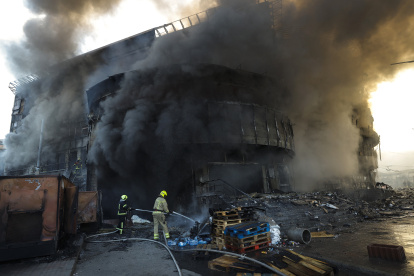 El humo se eleva mientras los rescatistas ucranianos trabajan en el lugar de un ataque ruso contra un centro comercial en Kiev, Ucrania.