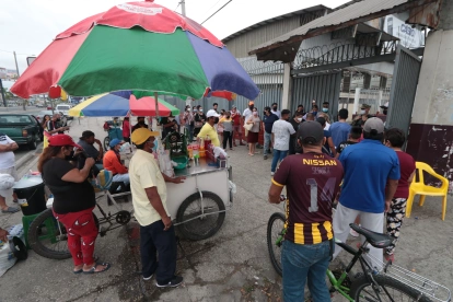 Un grupo de trabajadores informales fuera de una institución en Guayaquil.