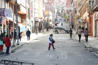 Personas caminan por una vía cerrada durante una jornada de bloqueos por parte de transportistas este martes, en La Paz (Bolivia).