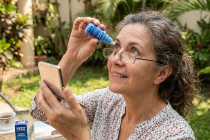 Un usuario aplica gotas VIZZ, el tratamiento que busca reemplazar los lentes de lectura.
