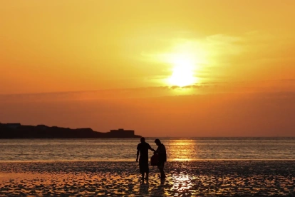 Personas pasean por una playa West Kirkby (Reino Unido). en una jornada calurosa.