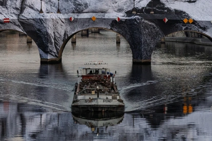 Una barcaza pasa junto a la instalación de “La cueva del Pont Neuf”, la última obra del fotógrafo y artista urbano francés JR.