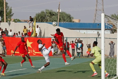 Los jugadores del Al Merrikh (de rojo) luchan por el balón con un jugador del Ahli Madani durante el partido inaugural de la Liga Premier Sudanesa, el 15 de mayo de 2026.