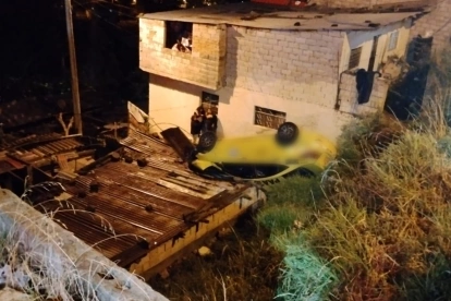 El taxi cayó aproximadamente seis metros por una pendiente, terminando en las inmediaciones de una vivienda.