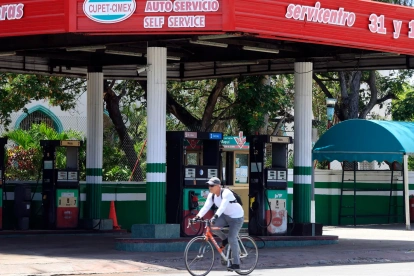 Una persona pasando en bicicleta frente a una estación de gasolina cerrada en La Habana (Cuba).