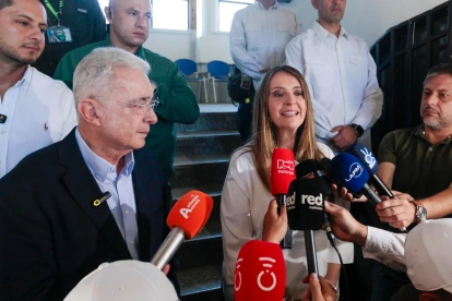 La candidata presidencial Paloma Valencia (c), acompañada del exmandatario Álvaro Uribe (i), habla a la prensa este domingo en Rionegro (Colombia).