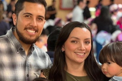 Mathias, de 3 años, junto a sus padres en una reunión con ambiente festivo.