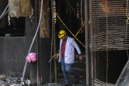 Un miembro del equipo forense inspecciona el hotel de Nueva Delhi en el que se produjo un incendio el 3 de junio de 2026.