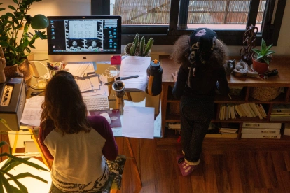 Referencial. En la imagen de archivo, una mujer realiza teletrabajo en su casa mientras su hija juega a su lado.