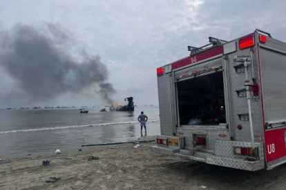 Bomberos trabajan para controlar los focos reactivados del incendio en el puerto de Manta, una de las emergencias más graves para el sector pesquero.