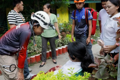 Personal de respuesta a emergencias habla con un estudiante que se sintió indispuesto tras un terremoto en la ciudad de Davao, en el sur de Filipinas, el 8 de junio de 2026.