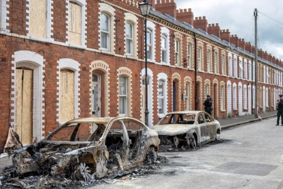 Se puede ver un coche calcinado en la calle McMaster tras los disturbios ocurridos en Belfast, Irlanda del Norte, el 10 de junio de 2026.