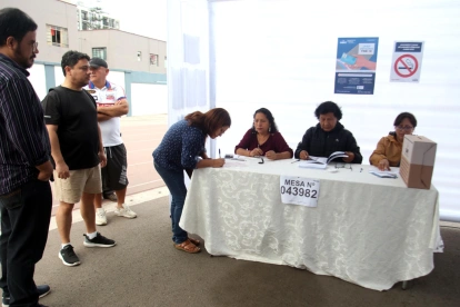 Ciudadanos cumplen con el proceso de votación en una mesa electoral en Perú.