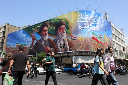 Ciudadanos iraníes pasan junto a una gran valla publicitaria con la imagen del difunto líder supremo iraní, en una calle de Teherán, Irán, este 10 de junio de 2026.