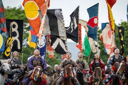 Jinetes ataviados con armadura de samurái miran al cielo mientras luchan por una bandera durante el festival Soma Nomaoi en Minamisoma, prefectura de Fukushima, el 24 de mayo de 2026.