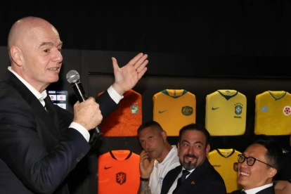 El presidente de la FIFA, Gianni Infantino, se dirige al público durante un evento oficial rodeado de camisetas históricas de selecciones nacionales.