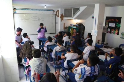 En la Escuela Franklin Roosevelt, en la calle Buenos Aires, en Quito, maestra hace ejercicios de gimnasia cerebral con estudiantes de 12 años.