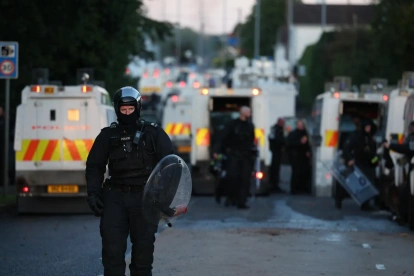 Un agente de policía camina con equipo antidisturbios en el lugar de los disturbios antiinmigración en Antrim Road en Newtownabbey, al norte de Belfast, Irlanda del Norte.