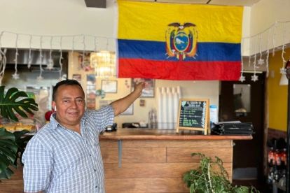 Segundo López posa con orgullo junto a la bandera tricolor que adorna su restaurante, "El Sazón de Doña Eva", en Upper Darby.