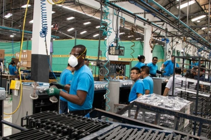 Un grupo de trabajadores cumple con su jornada laboral en una fábrica.