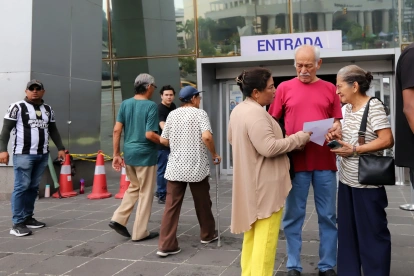 Adultos mayores en el exterior del edificio del Servicio de Rentas Internas, en Guayaquil.