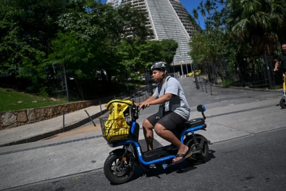 El repartidor de comida a domicilio Joao Paulo Teixeira, de 20 años, entrega un pedido para la aplicación 99Food en su bicicleta eléctrica en el centro de Río de Janeiro, Brasil, el 17 de abril de 2026.