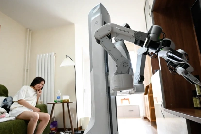 Esta fotografía, tomada el 21 de mayo de 2026, muestra un robot X Square organizando objetos en un estante en la casa de un cliente en Pekín.