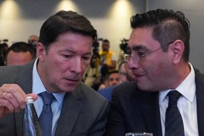El registrador Hernán Penagos (i) y el presidente del Consejo Nacional Electoral (CNE), Cristian Quiroz, hablan durante la instalación de la Misión de Observación Internacional.