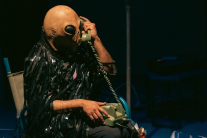 La obra transcurre en un espacio íntimo que remite a una sala. Desde allí, el intérprete comparte pensamientos, canciones y acciones performáticas