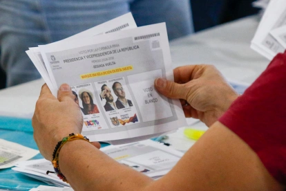 Ciudadano sostiene la papeleta de la segunda vuelta presidencial en Colombia, mientras el CNE reinicia el escrutinio sin definir aún al ganador.
