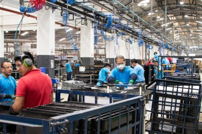 Un grupo de trabajadores cumple con su jornada de trabajo en una fábrica.