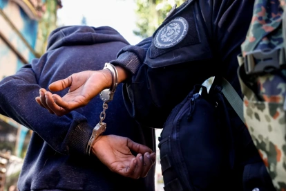Un integrante de la Policía Civil de Río de Janeiro custodia a una persona detenida en la "Operación Contención" este martes, en la favela de Santa Marta, en Río de Janeiro (Brasil).