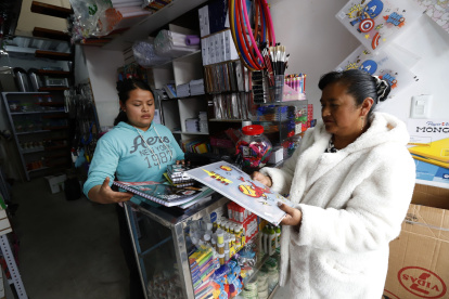 Madre de familia compara precios de útiles escolares en la Sierra ecuatoriana.