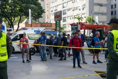Personas observan las labores de rescate y remoción de escombros tras los terremotos en Chacao, Caracas.
