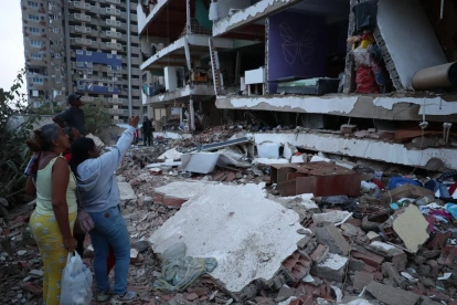 Residentes entre los escombros de uno de los bloques de viviendas dañados por los terremotos, en el estado costero de La Guaira (Venezuela) este jueves.