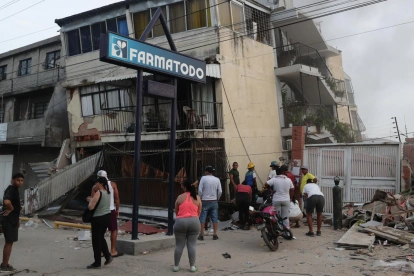 Residentes permanecen en la calle junto a viviendas dañadas tras los terremotos en Catia La Mar, estado La Guaira.