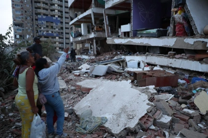 Residentes permanecen entre los escombros de viviendas colapsadas tras los terremotos en Catia La Mar, estado La Guaira.