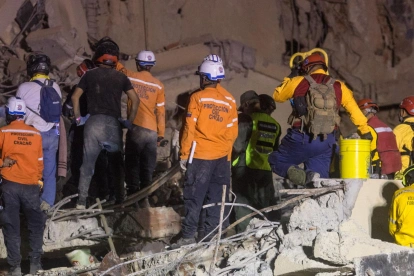 Integrantes de Protección Civil y voluntarios trabajan entre los escombros tras el terremoto en Venezuela.