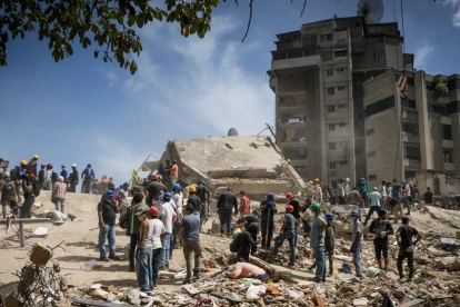 Rescatistas y voluntarios buscan víctimas en una vivienda afectada por los terremotos este jueves, en el municipio Libertador en el este de Caracas (Venezuela).