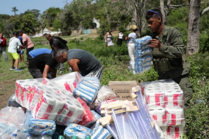 Personas descargan ayudas humanitarias este lunes en La Guaira, Venezuela, tras los sismos.