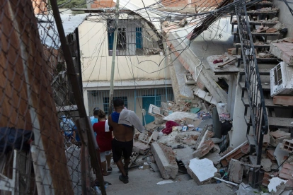 Personas buscan entre los escombros de las edificaciones destruidas por los terremotos.