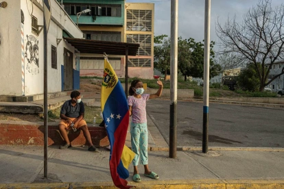 Una niña sostiene una bandera de Venezuela en una zona afectada por el doble terremoto de magnitud 7,2 y 7,5.