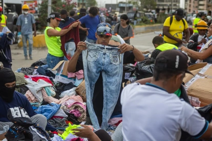 Personas buscan ropa en un campamento instalado frente a los edificios que se derrumbaron durante los terremotos en La Guaira, Venezuela, 30 de junio de 2026.