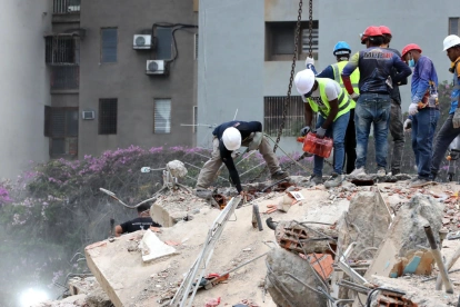 Rescatistas inspeccionan escombros en Caracas durante las operaciones de búsqueda tras los terremotos.