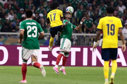 Julián Quiñones (abajo) de México disputa el balón con Angelo Preciado de Ecuador.