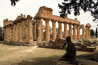 Un hombre se sienta a la sombra frente al Templo de Zeus en el sitio arqueológico de Cirene,en la costa mediterránea nororiental de Libia, el 18 de mayo de 2026.