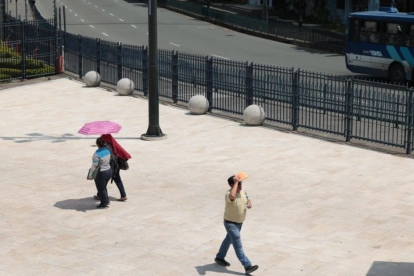 Ciudadanos en el centro de Guayaquil utilizan sombrillas y gorras para protegerse del alto índice de radiación UV que golpea a la urbe.